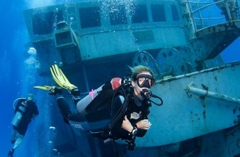 Diver hovering in front of a shipwreck